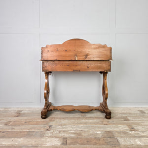 A farmhouse-style antique pine washstand dating to the late 19th century, with a shaped gallery back, two drawers and a lower shelf. The drawers retain brass swan neck handles, and the piece is raised on shaped supports with ball feet.