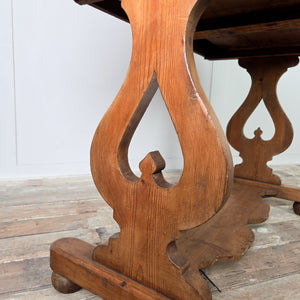 An antique Victorian pine washstand featuring a shaped gallery back running around the rear and sides, two small drawers with brass swan neck handles and a lower shelf. The waxed pine finish highlights the grain, and the piece stands on shaped supports with ball feet.