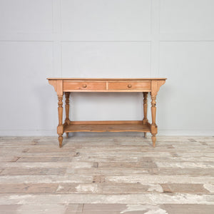 Victorian antique pine washstand from the 19th century, featuring two drawers with wooden knobs, a shaped lower shelf and four turned legs. Finished in a clear wax over a light pine patina. A rustic farmhouse and country piece suitable for use as a washstand, console table, hall table or dressing table.