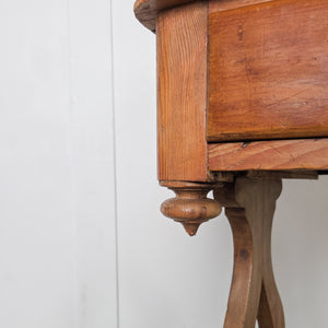 An antique Victorian pine washstand featuring a shaped gallery back, twin drawers and a shaped lower shelf. The drawers retain brass swan neck handles and the washstand stands on shaped supports finished with ball feet.
