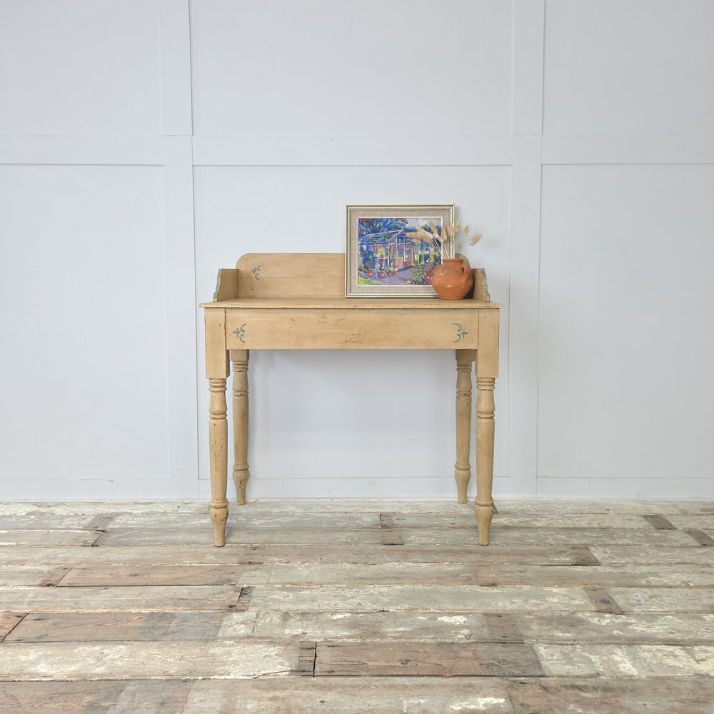An antique Victorian painted pine washstand from the 19th century, later finished in pale yellow with pale blue trim, featuring a shaped gallery back, four turned legs, and a lower shelf, making a versatile farmhouse console table or decorative accent for hallway or bedroom interiors.
