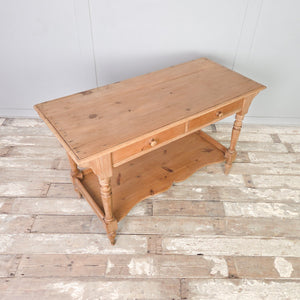 19th century Victorian pine washstand constructed in antique pine with two drawers, a shaped lower shelf and turned legs, finished in clear wax to protect the surface. Rustic and farmhouse in style, it works well as a washstand, console table, hall table or bedroom dressing table.