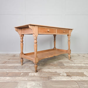 Victorian pine washstand dating from the 19th century, featuring two drawers, a shaped lower shelf and four turned legs, with a light pine finish sealed in clear wax. Rustic and country in character, this farmhouse piece can be used as a washstand, console table or dressing table.