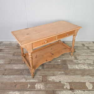 19th century Victorian antique pine washstand featuring two drawers with wooden knobs, a shaped lower shelf and turned legs, sealed in a clear wax finish. Country and farmhouse in style, it is well suited for use as a washstand, console table, hall table or bedroom dressing table.
