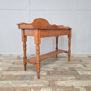Antique Victorian pine washstand, raised on four turned legs with a gallery back and shaped shelf below. Perfect for use as a farmhouse console table or side table, combining practicality with 19th century antique charm.