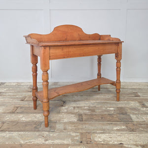 Antique Victorian pine washstand with decorative gallery back and lower shelf, standing on turned legs. A versatile piece of antique farmhouse furniture that can be styled as a console table, hallway side table or bedroom washstand, finished with a natural pine wax polish.