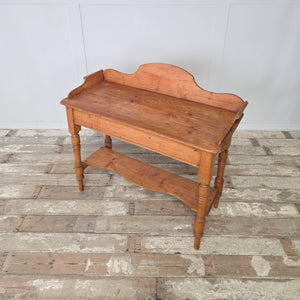 A 19th century Victorian pine washstand with gallery back, scroll sides and a shaped lower shelf, raised on turned legs. Perfect for farmhouse style interiors, this antique pine piece can be used as a console table, side table or washstand, showcasing authentic country charm.