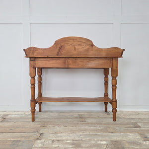 Victorian 19th century pine washstand, raised on turned legs with scroll gallery back and shaped lower shelf. A rustic farmhouse console table or side table option, crafted from pine and finished with a wax polish to highlight its antique patina and traditional country style.