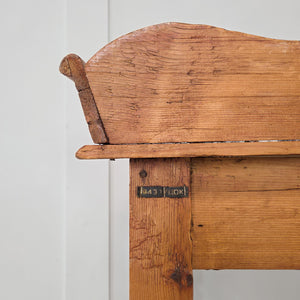 A Victorian pine washstand dating to the 19th century, with decorative gallery back and lower shelf for storage or display. Raised on four turned legs, this antique pine piece works well as a farmhouse console table, rustic side table or traditional washstand for interiors.