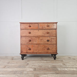 Victorian painted pine chest of drawers with five graduating drawers and four contrasting dark bun feet below it
