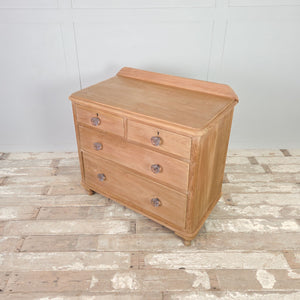 Antique 19th-century pine drawers featuring a light patina and solid turned bun feet.

