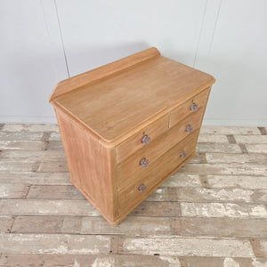 	Victorian storage chest in stripped pine with two short over two long drawers and bun feet.
