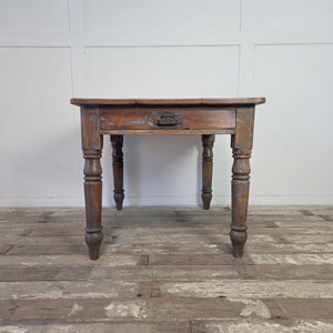 Rustic antique pine farmhouse table with a distressed painted apron and turned legs
