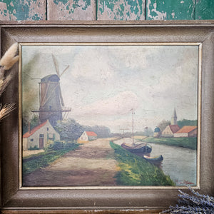 Vintage oil canvas showing a quiet waterway bordered by simple houses.
