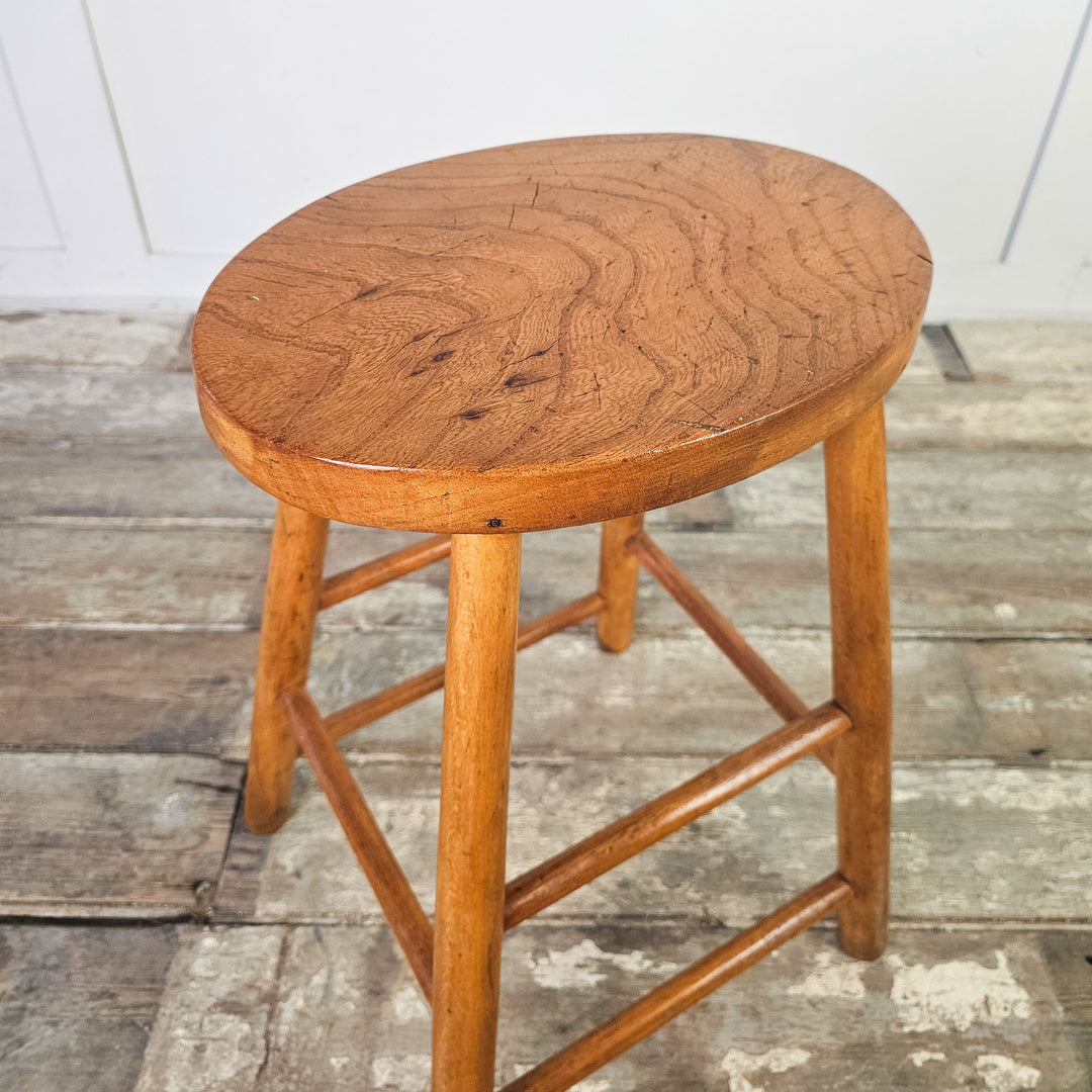 Sturdy elm stool with four legs and supportive stretchers from the mid-century.
