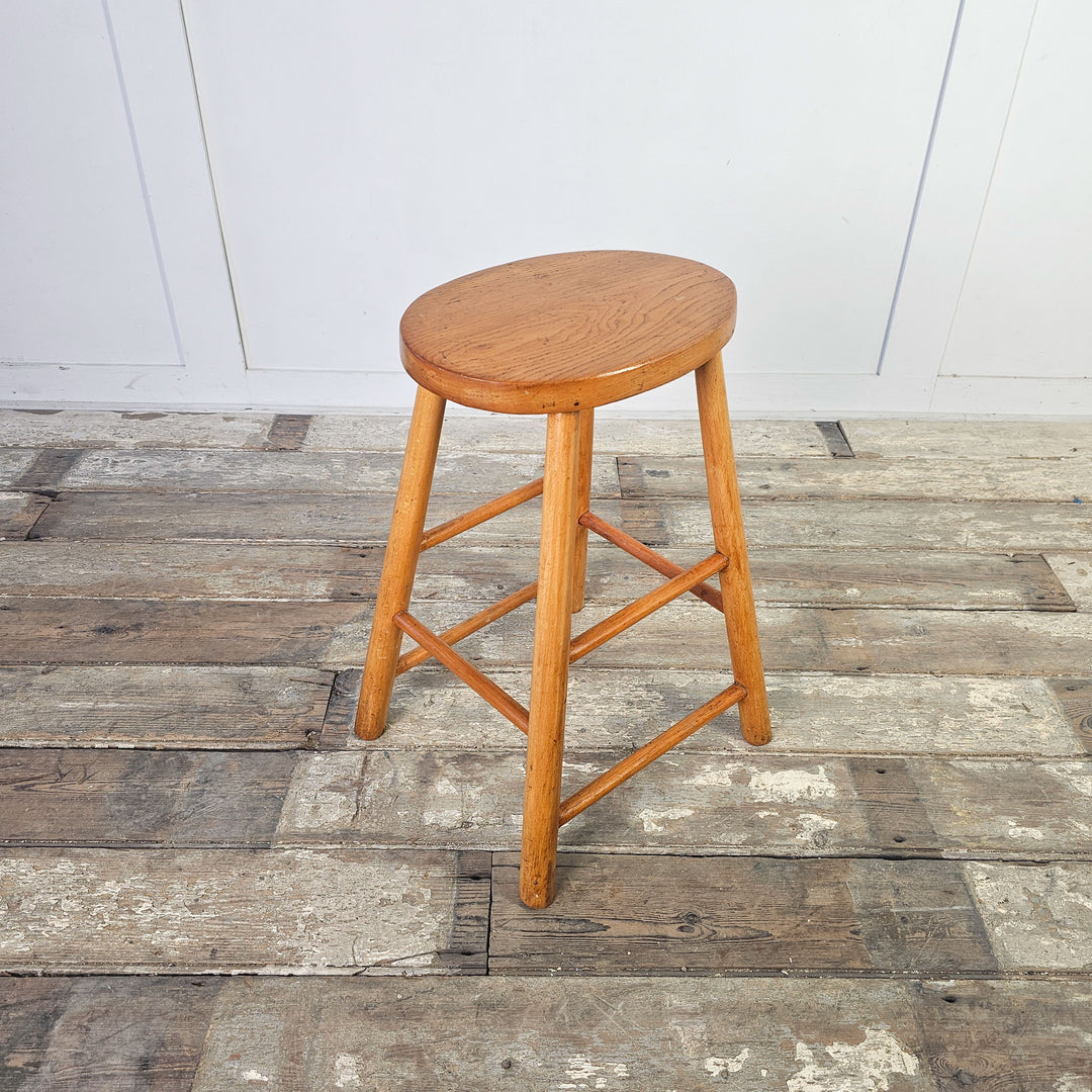 Sturdy elm stool with four legs and supportive stretchers from the mid-century.
