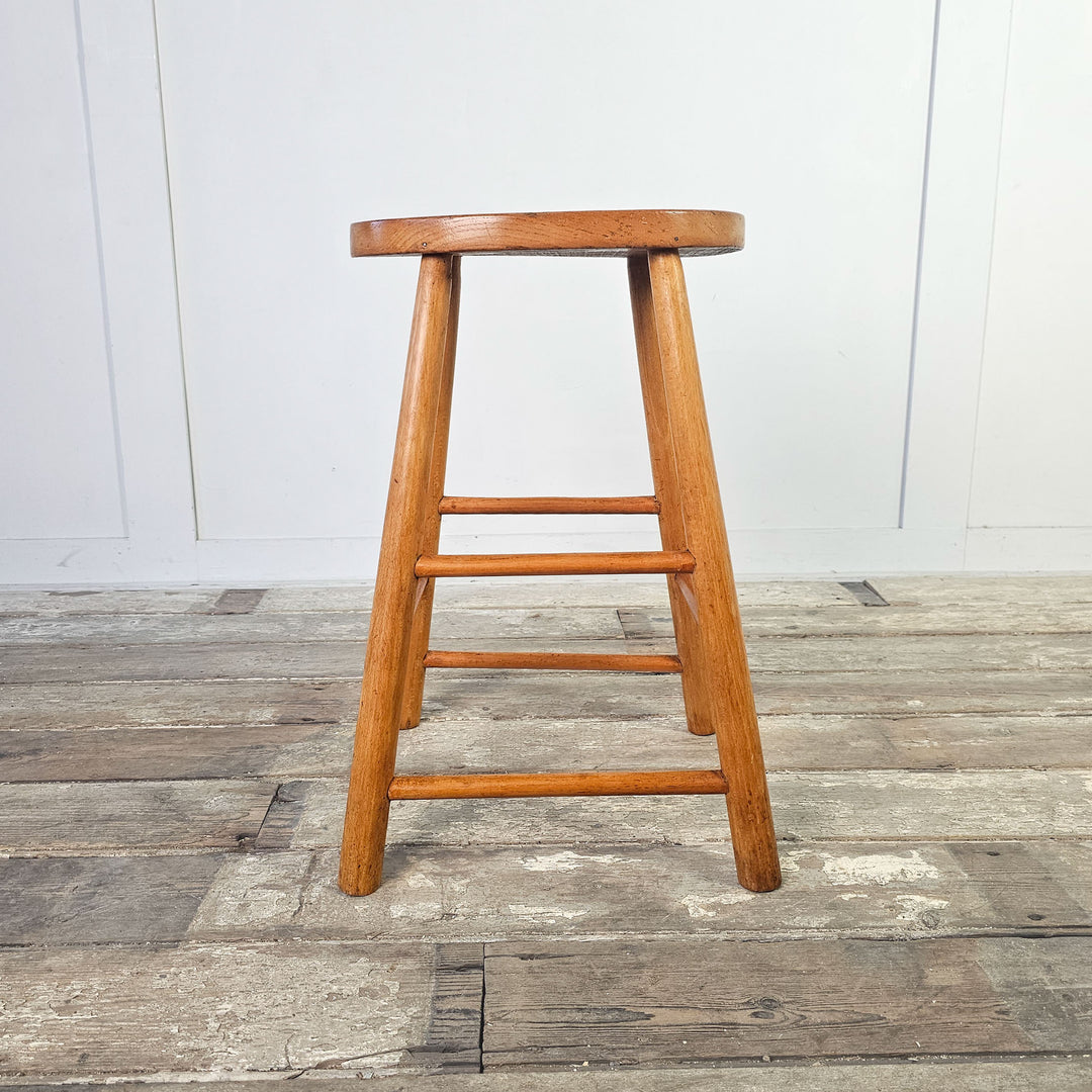 Art studio style elm stool with oval seat and simple leg design.
