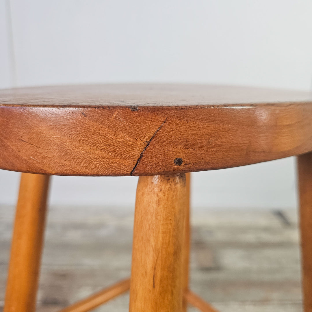Classic elm stool with oval top and straight legs, mid-century design.
