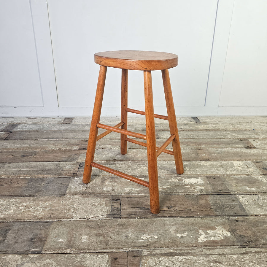 Vintage-inspired mid-century stool with unique patina and oval seat.
