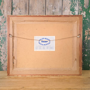 A gilt framed oil on board painting of a rustic countryside landscape, signed and dated 1984. Shows a large country house with smaller outbuildings and meadow grasses leading to rolling hills. The palette mixes golden yellows, bright oranges and deep greens, typical of vintage landscape wall art.