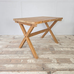 Vintage pine trestle table with an X-frame base and substantial rectangular top, stripped back to reveal its natural patina and sealed with wax for protection. This farmhouse style piece is versatile, working equally well as a kitchen dining table, a study desk, or a rustic console table for hallways.