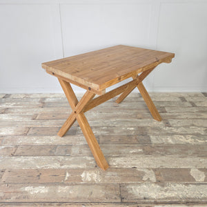 A vintage pine X-frame trestle table dating to the mid-20th century, stripped back to its natural finish and sealed with clear wax. Features include a thick rectangular top with visible grain and a sturdy X-frame base. A farmhouse style table suitable for dining, working, or use as a console in the home.