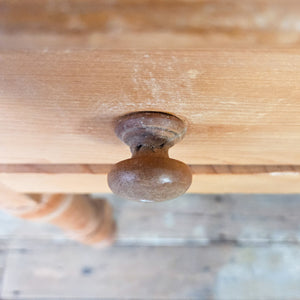 A vintage pine console table with two drawers and a shaped gallery back, supported on four turned legs. This country-style piece works well as a hall table in a hallway or living space, while also lending itself to use as a dressing table in a bedroom.