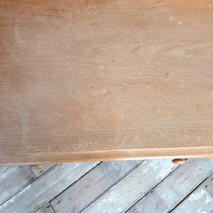 A rustic vintage pine washstand featuring two drawers with matching wooden knobs and a shaped gallery back. Raised on four turned legs, the table works well as a traditional washstand in a bathroom or as a dressing table in a bedroom.
