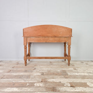 A large vintage pine hall table with two drawers and a shaped gallery back, supported on four turned legs. This farmhouse console table works well in a hallway or living room, while the drawers offer useful storage for smaller everyday items.