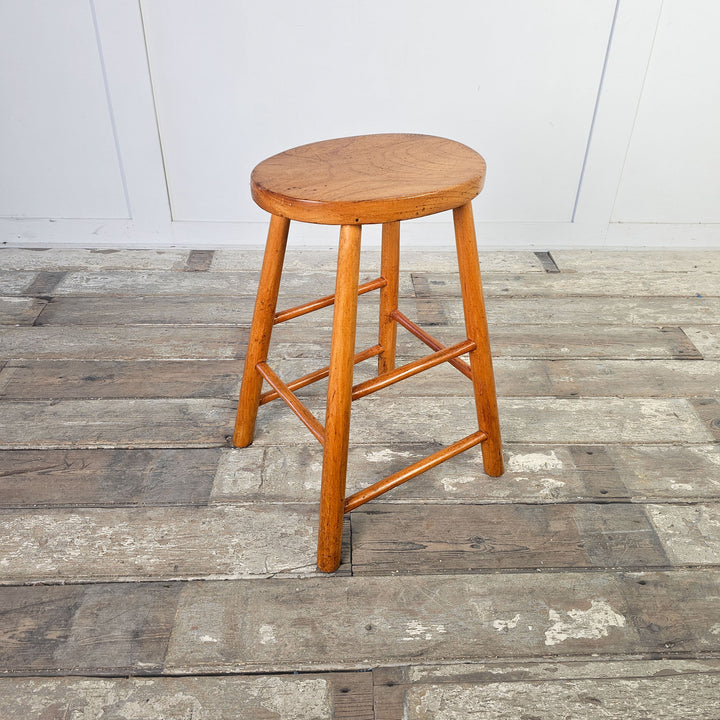 Mid-century design elm stool with straight legs and oval top.
