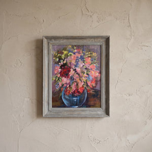 A vintage floral still life oil painting of mixed garden flowers in a blue vase, painted in impasto style and dated 1990.
