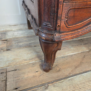Antique French Louis XV style chest of drawers in walnut, with a serpentine front, four drawers increasing in depth, and decorative brass plate drop handles.
