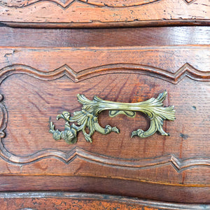 Antique French chest of drawers in walnut, featuring a serpentine front, four graduating drawers, ornate brass hardware, and short curved cabriole legs.
