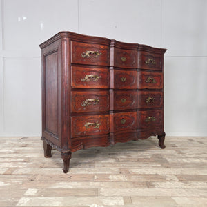 Antique French serpentine chest of drawers made from walnut, with four full-width drawers, original brass handles, and curved cabriole legs.

