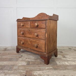 A rustic pine Victorian chest with four drawers, wooden knobs and a shaped gallery to the top. Set on later bracket feet, this farmhouse style storage chest suits country house style interiors and provides practical bedroom drawer storage.