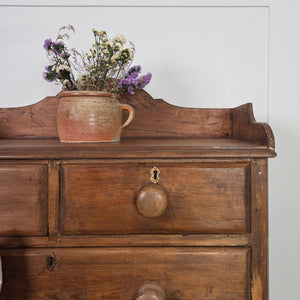 A farmhouse style Victorian four-drawer chest made from rustic pine, featuring wooden knobs, a shaped gallery and bracket feet. Its simple two-over-two layout provides versatile storage suited to bedrooms, hallways or living spaces.