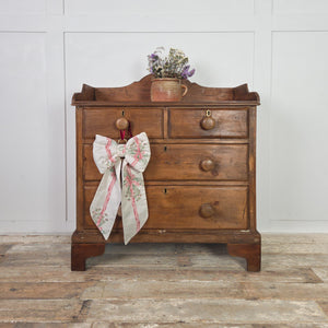 A late 19th-century Victorian pine chest of drawers in a rustic pine, farmhouse style. Built in a two-over-two layout with wooden knobs, a shaped gallery top and later bracket feet, offering practical bedroom drawers or a compact country house style storage chest.
