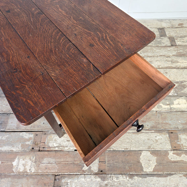Antique Welsh oak dairy table from the 19th century, constructed with a planked oak top of four boards and a drawer running the width of the apron. Slim legs and H-shaped stretcher provide support. Farmhouse table for use as hall table or side table.