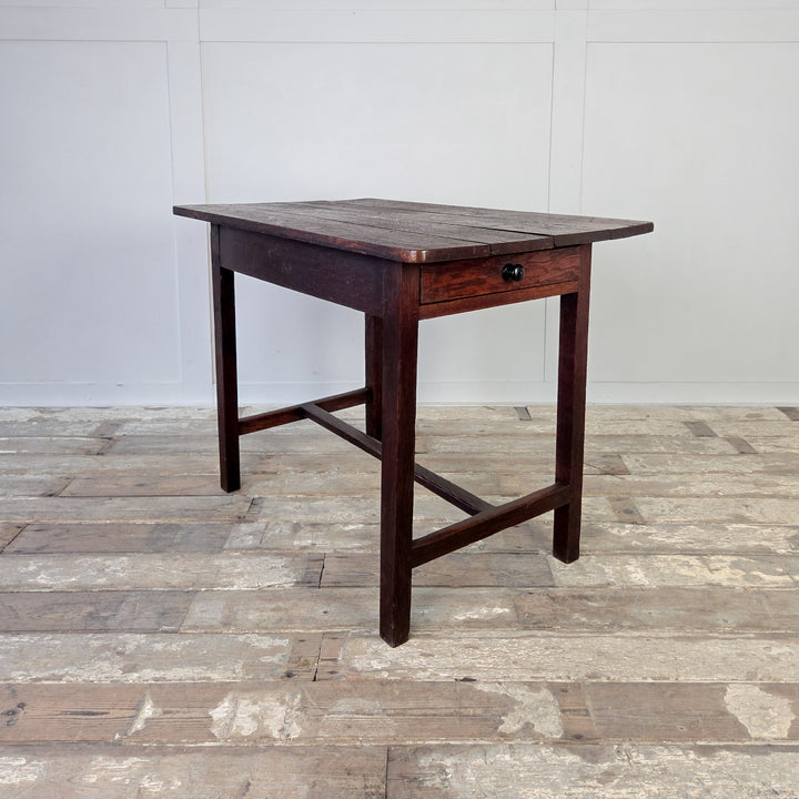 A 19th century Welsh oak dairy table with a four-plank top and full-length drawer, supported by slim straight legs and a lower H-stretcher.