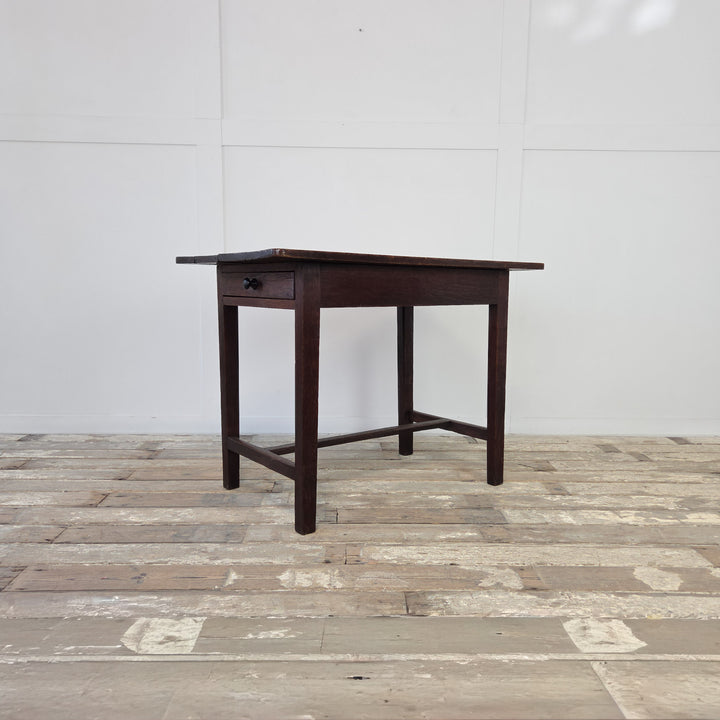 Antique Welsh oak dairy table from the 19th century featuring a four-plank rectangular top, single full-length drawer with original knob, and slim legs with H-shaped stretcher. Perfect farmhouse table for use as a hall table or kitchen table.
