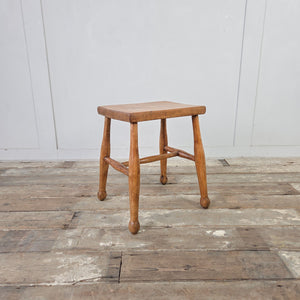 Antique rustic milking stool in elm with thick plank seat and turned legs
