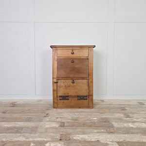 Early 20th century antique workshop drawers made from mixed timber, featuring two useful drawers and a small lower cupboard with a drop-down front. The rugged, industrial character reflects its workshop origins, making it well suited for use as a bedside table in the bedroom or an end table in the hallway or living room.
