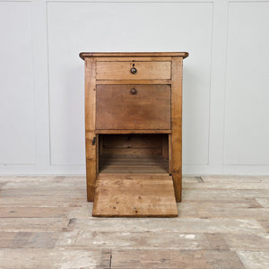 An early 20th century antique workshop drawer unit constructed from mixed timbers, featuring two drawers for smaller items and a lower cupboard accessed via a hinged drop-down door. The industrial-style design lends itself well to use as a bedside table in the bedroom or as an end table in the hallway or living room.
