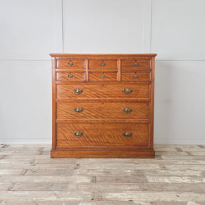 Large antique satin birch chest of drawers with reeded side columns and simple moulded plinth base