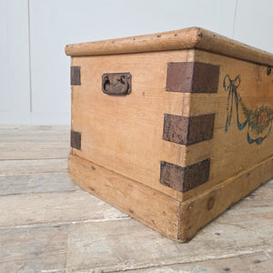 Antique painted blanket chest with folk art floral decoration to the front panel and iron banding to all four corners
