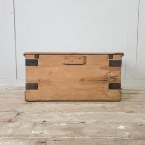 Antique French folk art storage chest with blue ribbon and floral garland painted to the front and hinged lid above
