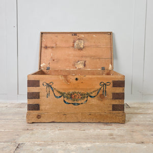 French antique storage chest with folk art floral decoration, iron corner banding and original paper lining to the interior
