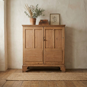 Georgian antique pine cupboard with fielded panel doors, moulded cornice above, and a turned wooden knob.
