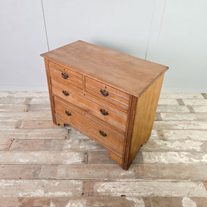 Early 20th century antique ash four drawer chest of drawers featuring reeded drawer fronts and brass swan-neck handles on backplates.