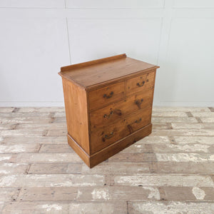 Cottage style pine chest of drawers with four graduating drawers, brass swan neck handles and plinth base
